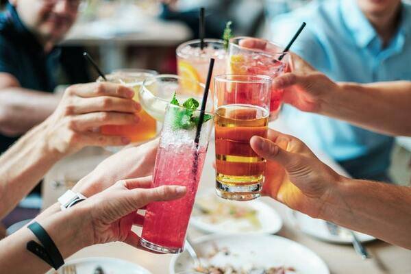 A couple of passengers cheering with their cocktails | 600x400