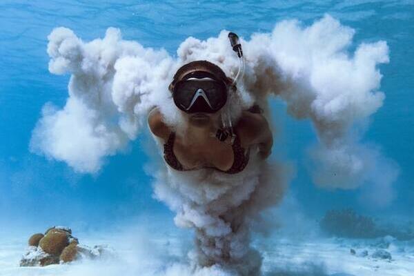 A person swimming through sand underwater | by Israel Gil 600x400