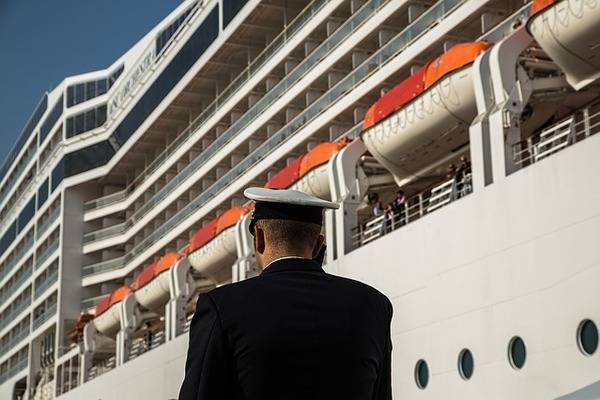 Officer on the pier with a cruise ship in the background | 600x400