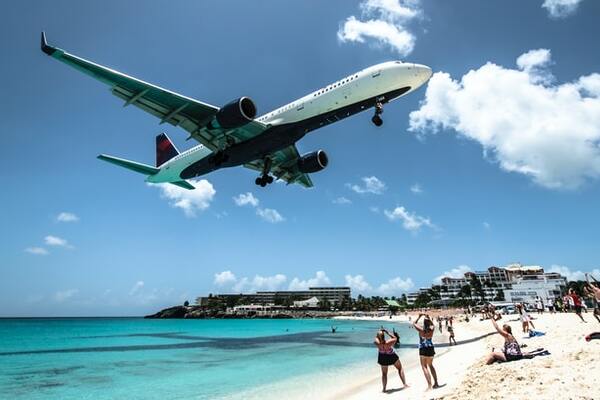 Plane approaching Maho Beach in Sintt Marteen, Caribbean at a couple of meters on top of beachgoers head. | by Ramon Kagie 600x400