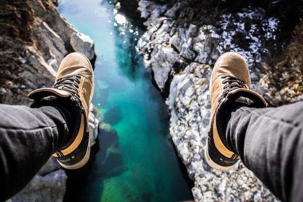 Shoes hanging off a bridge or a cliff over water | by Marko Horvat 600x400