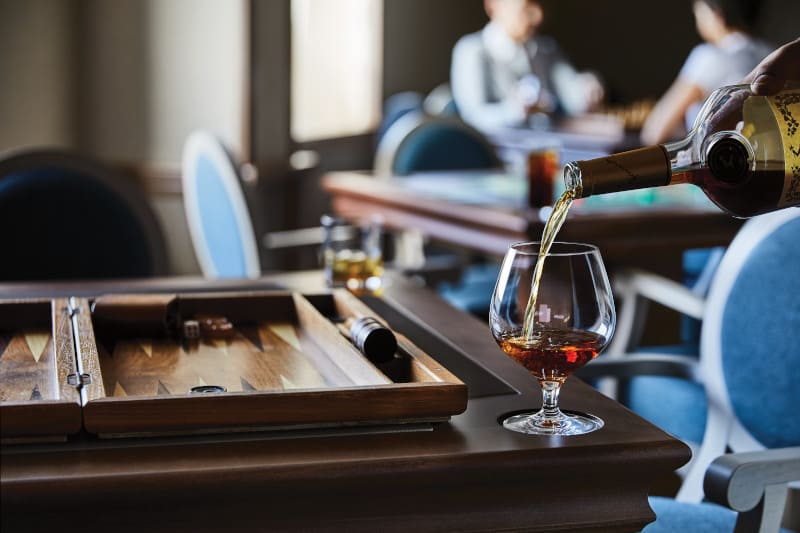 A luxurious card room onboard the Silver Cloud cruise ship, featuring a glass of fine Cognac. The elegant decor adds to the refined ambiance