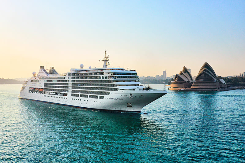 Silversea Cruises' luxurious Silver Muse gracefully approaches the Sydney Harbour, framed by the iconic Opera House and glittering cityscape.